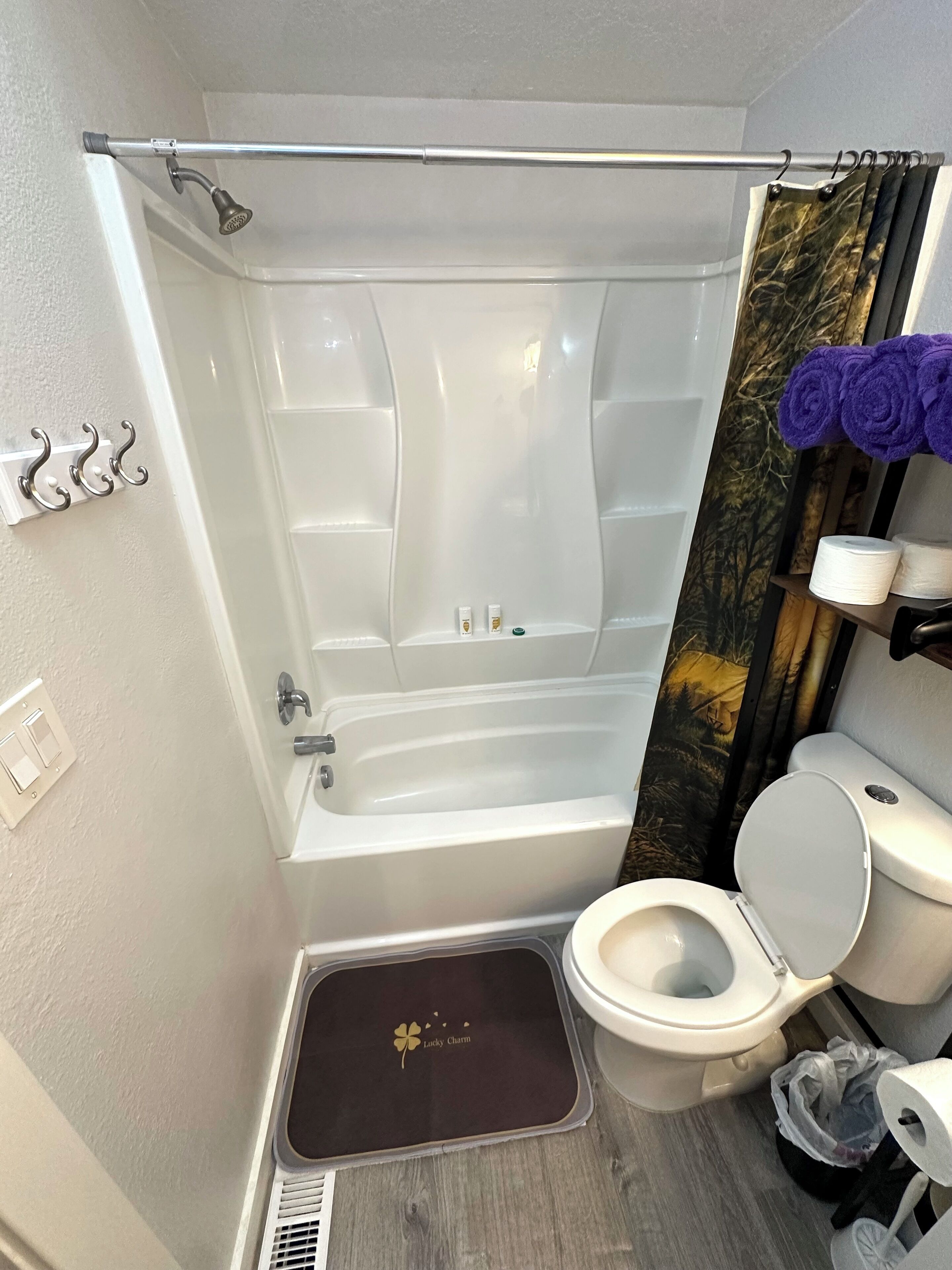 A bathroom with a bathtub, toilet, and shower curtain.