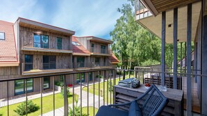 A modern multi-story building with wooden exterior and balconies. - New 2025 Pervalka Neringa Flat White Dunes: AC, Heating, Private Balcony (Pervalka)