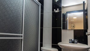 A bathroom with a toilet, a sink, and a shower enclosure. - Hotel Bossanova (Rionegro)