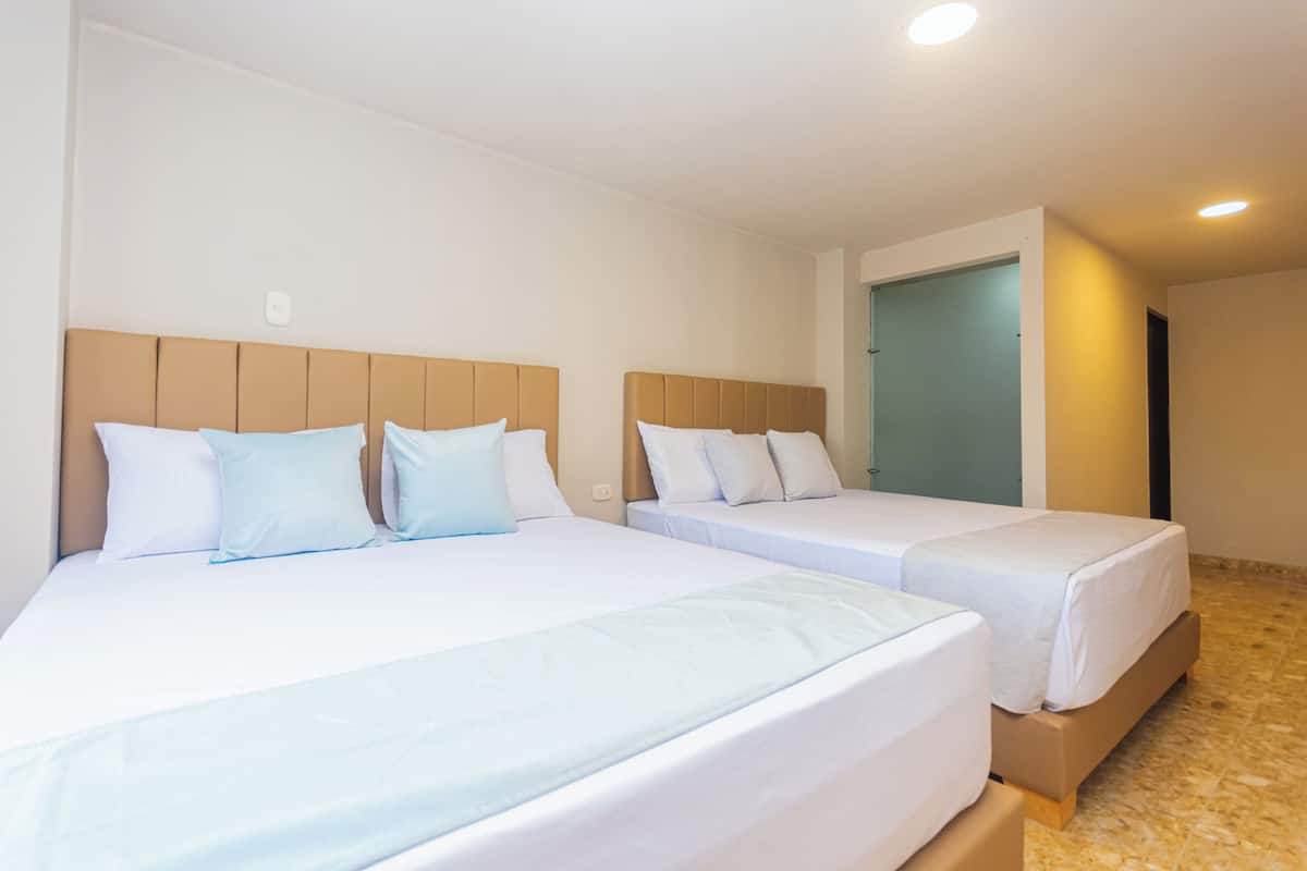 Two single beds with headboards, white bedding, and a tiled floor.