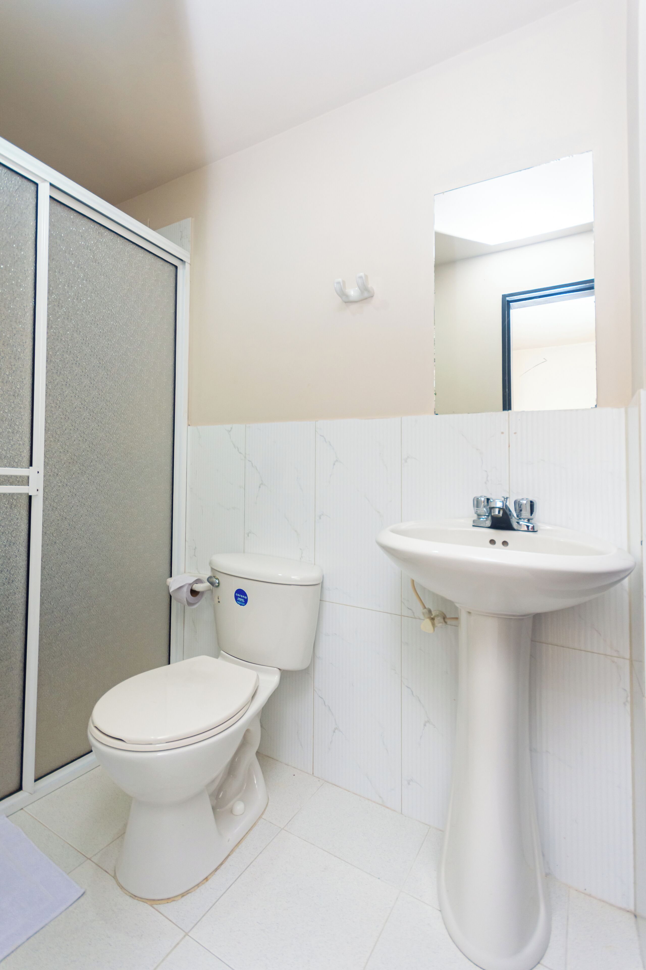 Un baño con inodoro, lavamanos y espejo.