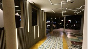 A corridor with patterned flooring, a modern ceiling design, and a column structure. - Hotel Bossanova (Rionegro)