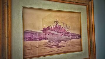 A framed photograph of a ship with the name "S.R.ANO" on its side, docked at a harbor with buildings in the background.