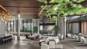 A spacious lobby with a modern design, featuring a bar area, seating arrangements, and large windows allowing natural light. - Medano Beach Cabo Resort 3 Bedroom  (Cabo San Lucas)