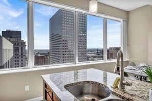 A modern kitchen with a large window, a stainless steel sink, and a granite countertop. - 21st Floor Penthouse  Amazing Views of Downtown! (Cleveland)