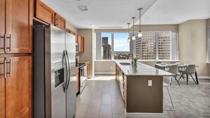 A modern kitchen with wooden cabinets, stainless steel appliances, and a large island.