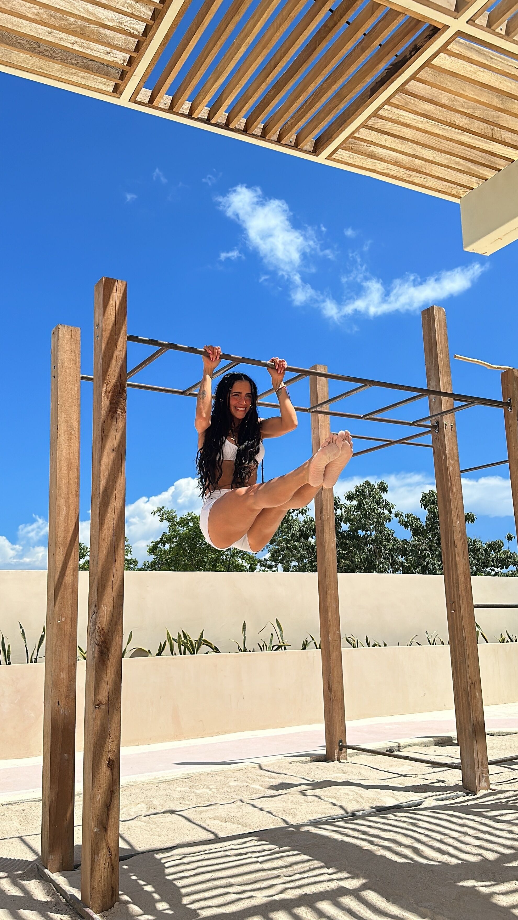 A person performing an exercise on a wooden structure outdoors.