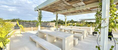 An outdoor seating area with concrete benches and a pergola structure.
