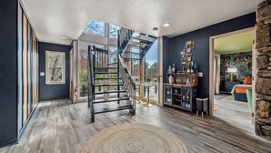 A modern interior with a spiral staircase, wooden flooring, and a stone accent wall.