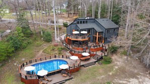 A large house with a swimming pool, deck, and outdoor furniture.