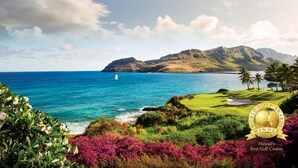 A golf course with a view of the ocean and mountains.