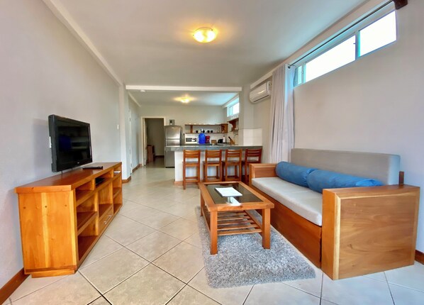 A modern living room with a wooden entertainment unit, a sofa, and a coffee table.