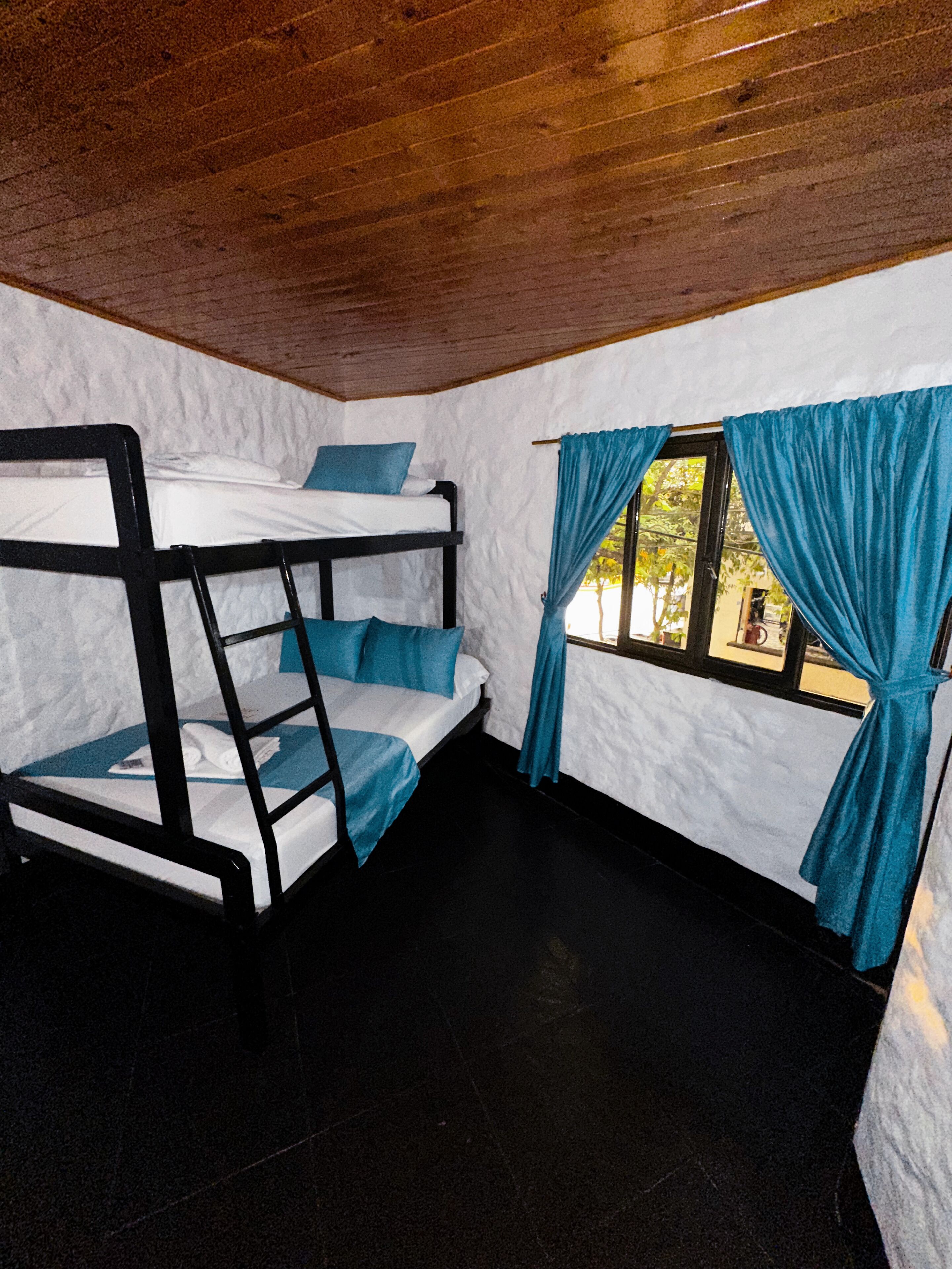 Ein Schlafzimmer mit Etagenbetten, Fenster und Vorhängen.