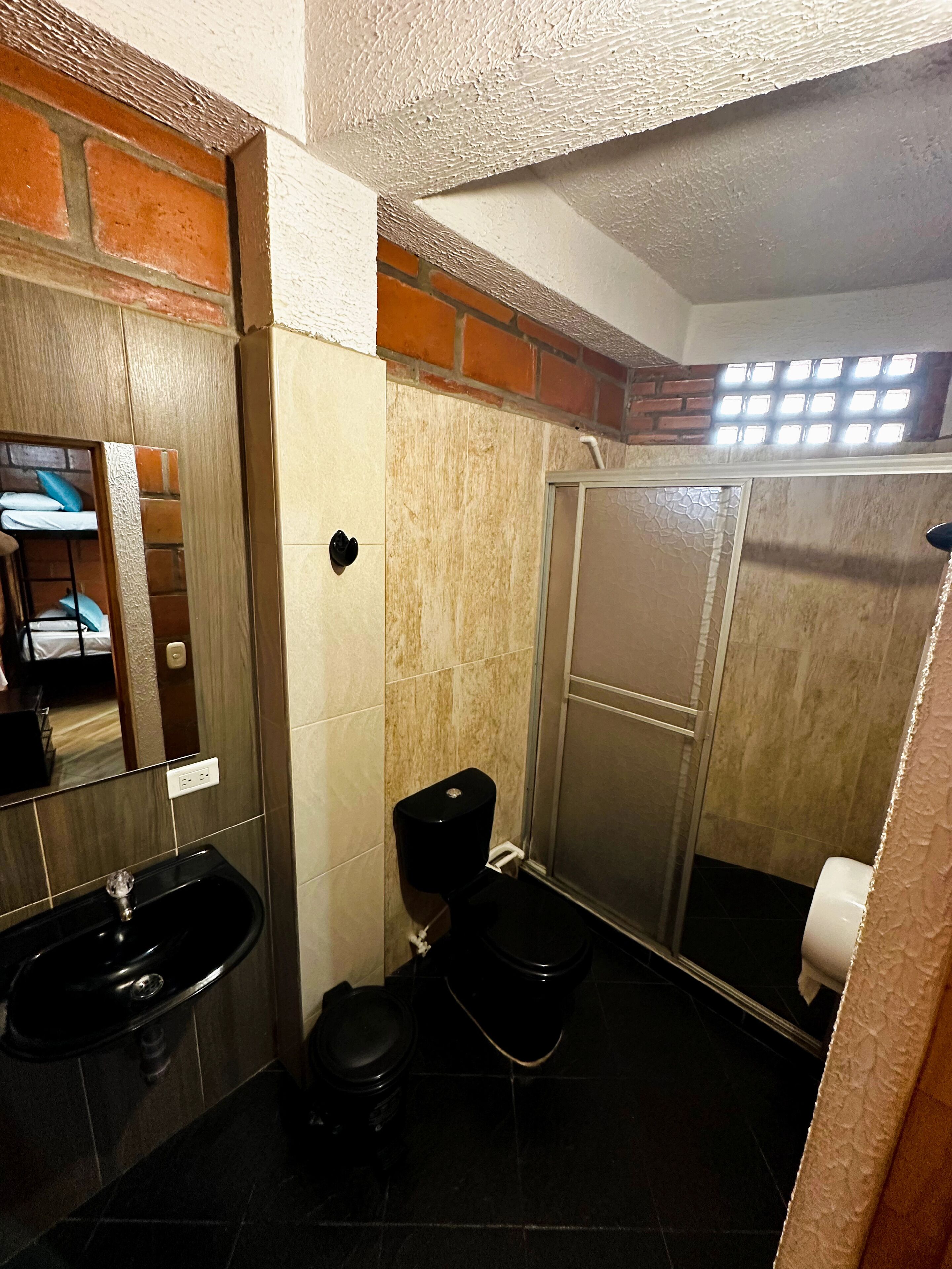 Un baño pequeño con lavamanos, inodoro y cabina de ducha.