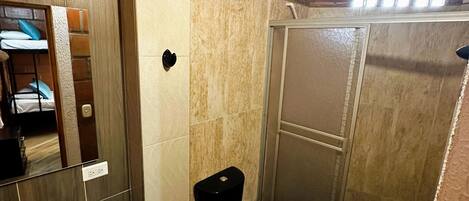Een kleine badkamer met een wastafel, toilet en douchecabine.