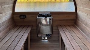 Un sauna avec vue sur un lac et une forêt.