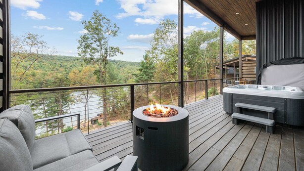 Une terrasse dotée d’un foyer extérieur, de coins salon et d’un jacuzzi.