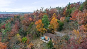 A house with a deck overlooking a forested area with autumn foliage. - Starstone Chalet - Hot Tub! Mountain Views! (Broadway)