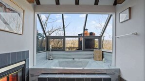 A modern bathroom with a glass-enclosed hot tub, a fireplace, and a view of the outside. - Slopeside Chalet: Ski & Bike in/out+Views+Hot Tub (Basye)