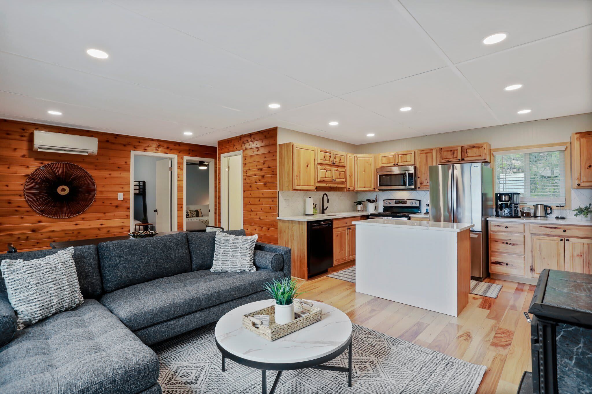 A modern kitchen with wooden cabinets, a central island, and a dining area.