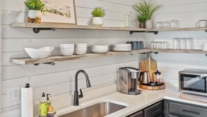 A modern kitchen with wooden shelves, a stainless steel sink, and a coffee maker. - Mountain View Cabin~HotTub~Fireplace~King Bed (New Market)