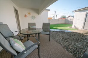 An outdoor patio area with a round glass table and four chairs. - Downtown Phoenix Cozy Home Close to Concerts, Bars, Airport + More! (Phoenix)