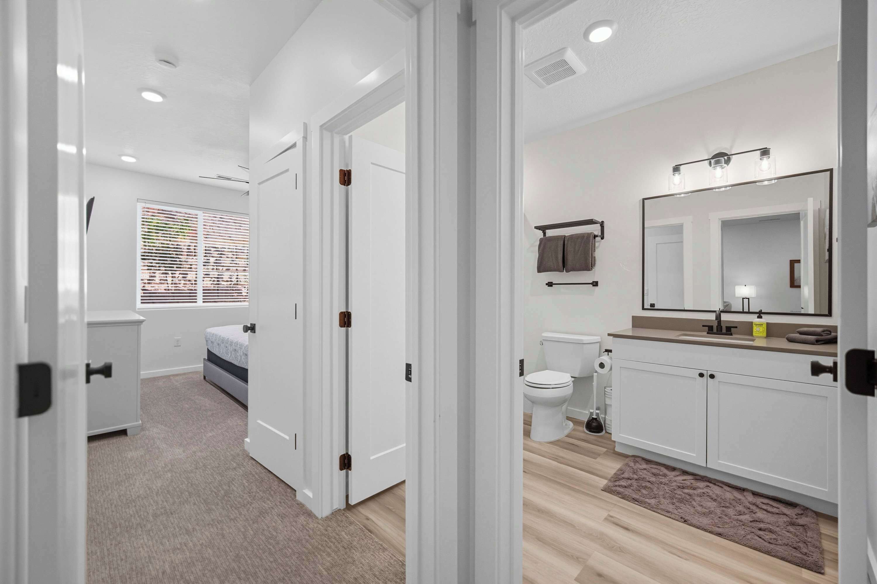 Un baño moderno con inodoro, lavamanos y espejo.