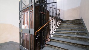 Una escalera con barandillas metálicas y una reja en la parte inferior.