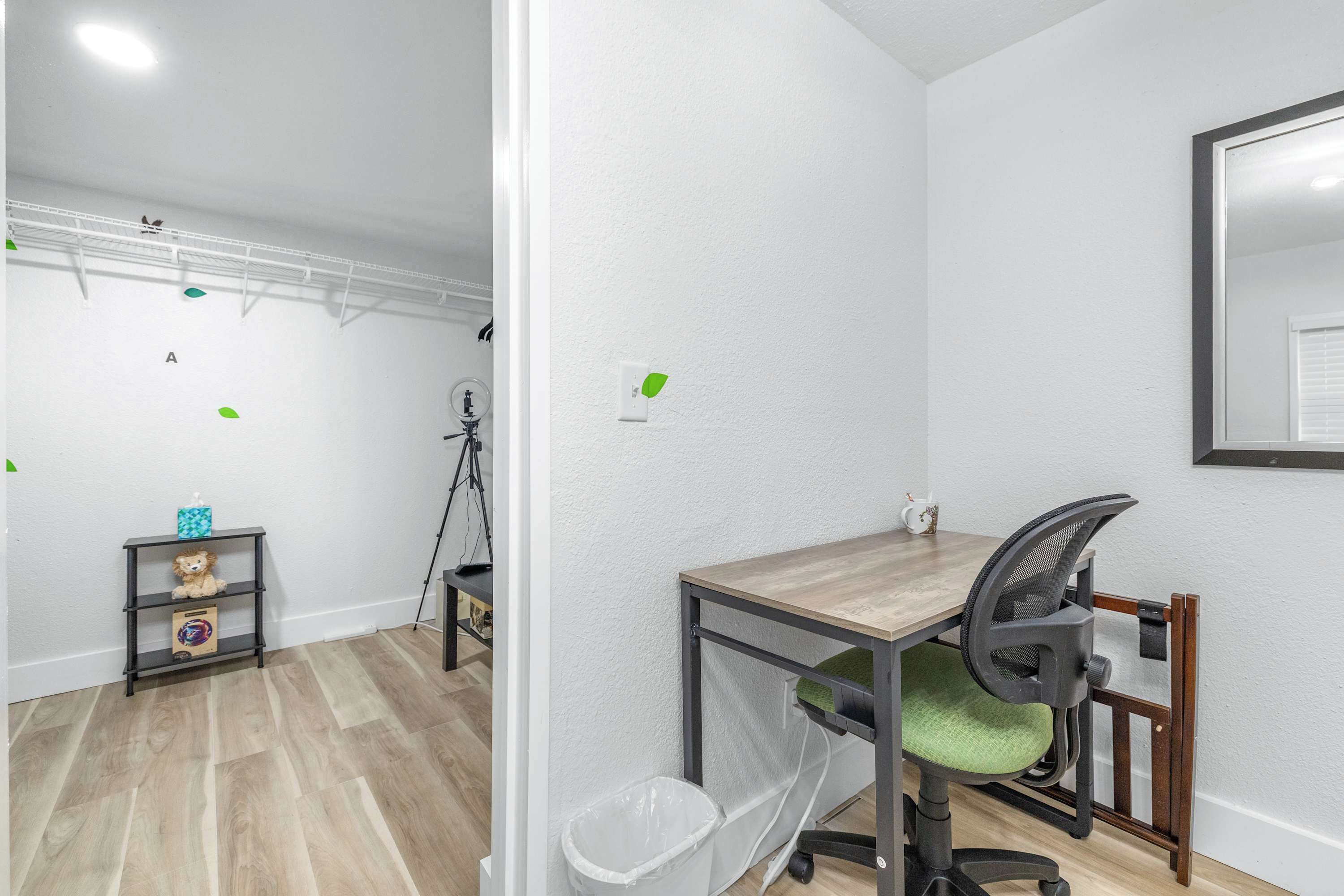 Un petit bureau comprenant un bureau, une chaise et une poubelle.