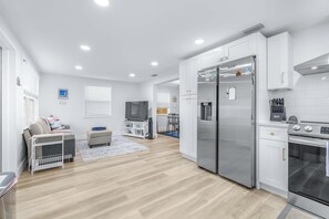 A modern kitchen with white cabinets, a stainless steel refrigerator, and an oven. - La Casita Stay for 6 Guests (Tampa)