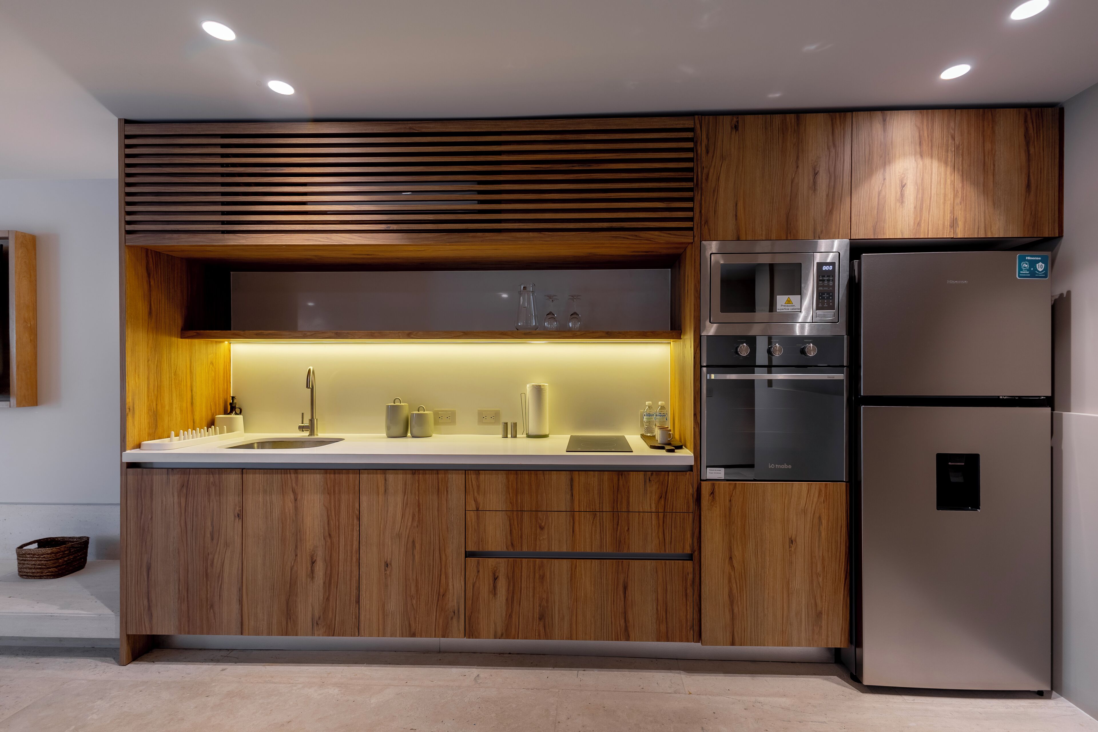 A modern kitchen with wooden cabinets, a stainless steel refrigerator, and built-in appliances.