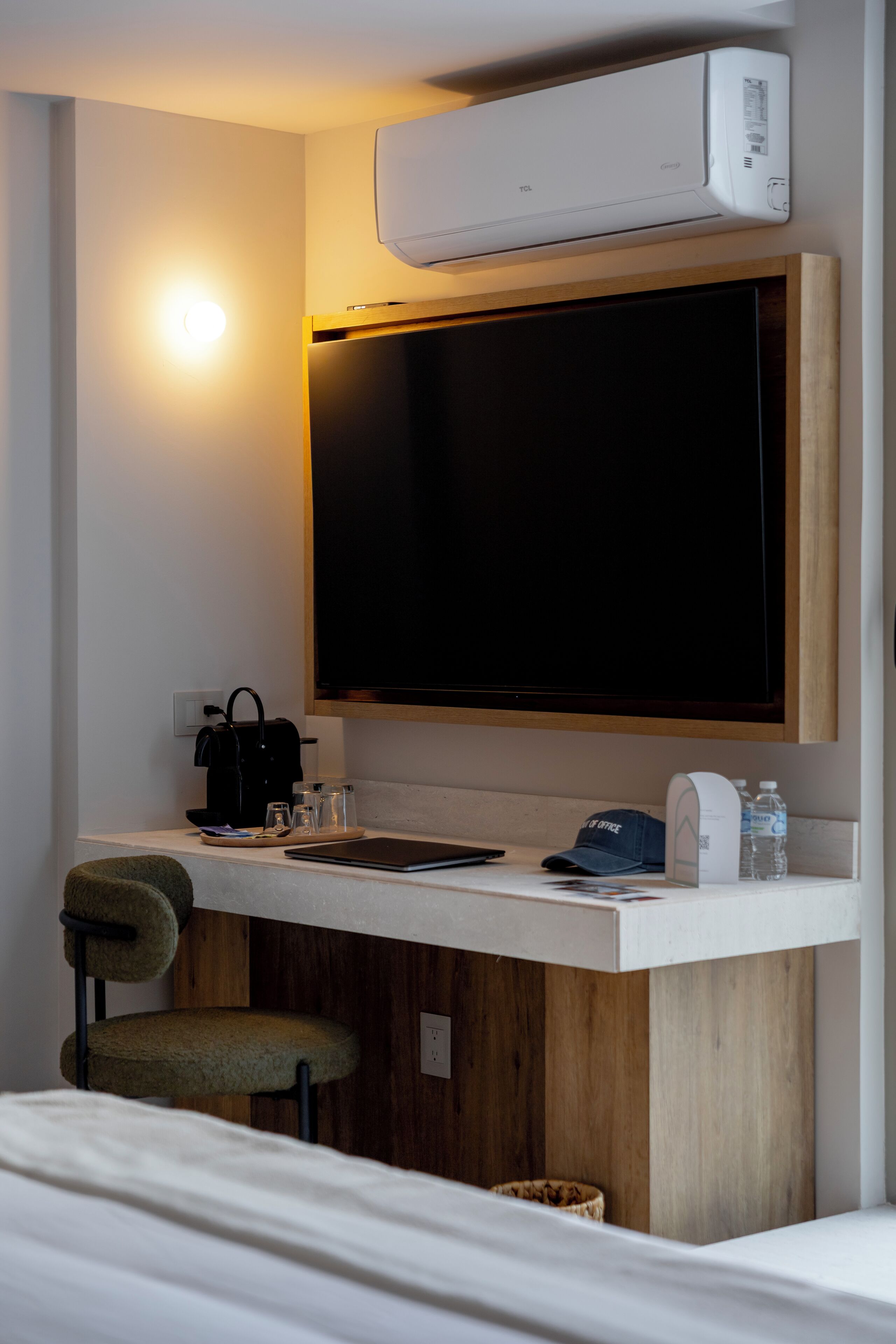 Une chambre d’hôtel moderne équipée d’une télévision à écran plat, d’un bureau avec une machine à café, d’une chaise et d’un lit.