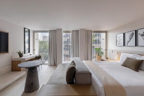 A modern hotel room with a large bed, a seating area, a small table, and a TV. - Capitalia Reforma Chapultepec (Mexico City)