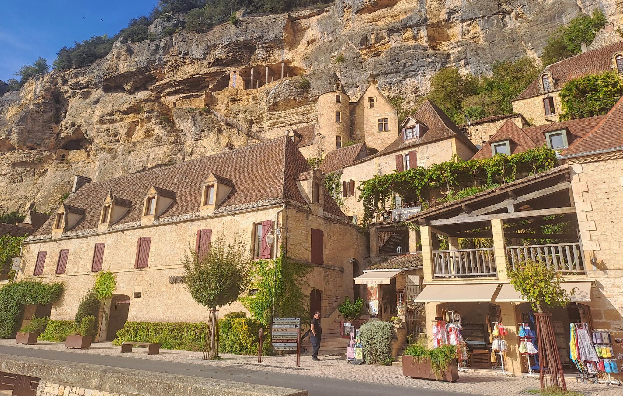 A stone building with a balcony and a sign for 'Les Terrasses de la'.