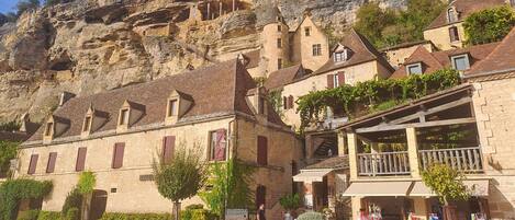 A stone building with a balcony and a sign for 'Les Terrasses de la'.