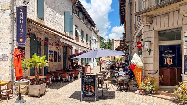 A cobblestone street with outdoor seating, a sign for 'ANDINE,' and a 'PACIFICO' menu board. - Lovely home in Saint-Aubin-de-Cadelec with WiFi (Saint-Aubin-de-Cadelec)