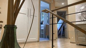 A modern interior with a wooden staircase, a glass railing, and a view into a room with a wardrobe and a door leading to another space. - Lovely home in Saint-Aubin-de-Cadelec with WiFi (Saint-Aubin-de-Cadelec)