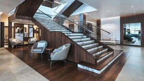 A modern interior with a central staircase, wooden flooring, and contemporary furniture. - AC Hotel Georgetown Guyana (Georgetown)