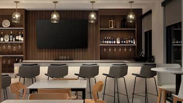 A modern bar area with a flat-screen TV, wooden shelves with bottles, and bar stools.