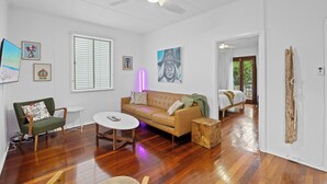 A spacious living room with a sofa, armchair, and a small round table. - Salt Soul South Freo - 3BR (Perth)