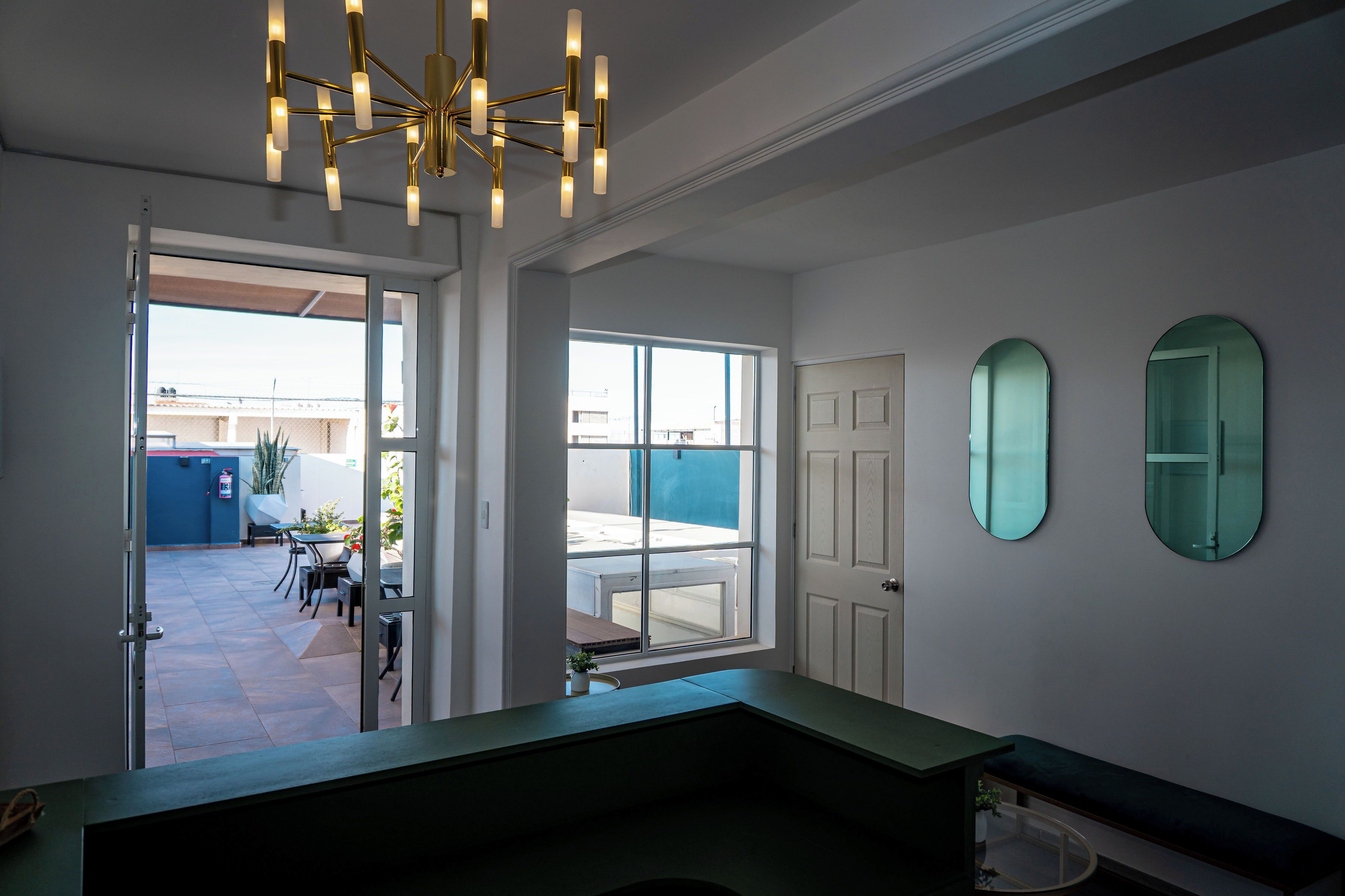 A modern interior with a large window, a bench, and a ceiling light fixture.