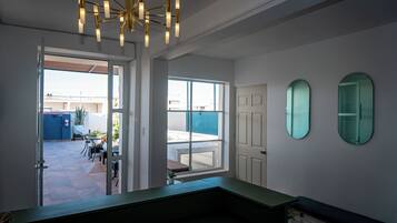 A modern interior with a large window, a bench, and a ceiling light fixture.