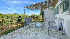 A patio with a glass table and chairs, a wooden fence, and a pergola. - Awesome home in Fontvieille (Fontvieille)