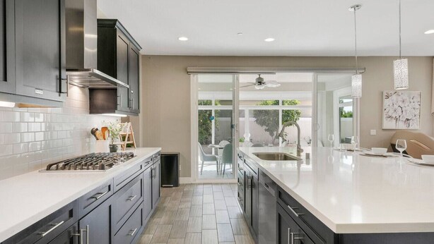 A modern kitchen with dark cabinets, a white countertop, and a large island. - Disneyland & Chill w/ Theater/Gameroom/HotTub AN18 (Anaheim)