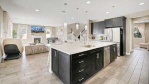 A modern kitchen with a large island, dark cabinetry, and stainless steel appliances. - Disneyland & Chill w/ Theater/Gameroom/HotTub AN18 (Anaheim)