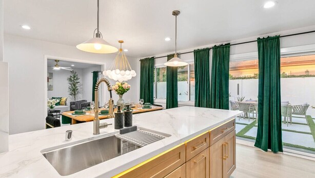 A modern kitchen with a marble countertop, wooden cabinets, and pendant lighting. - Foosball, Hot Tub, Big Backyard, Disneyland, AN12 (Anaheim)