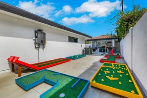 Un pati amb taula de bitlles, taula de ping-pong i una petita zona de jardí.