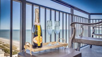 A balcony with a bottle of Chandon champagne, two glasses, and a wooden tray.