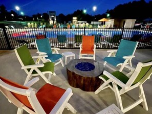 An outdoor seating area with lounge chairs and a central fire pit.