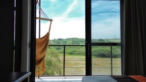 Una habitación con un amplio ventanal que da a un paisaje verde.
